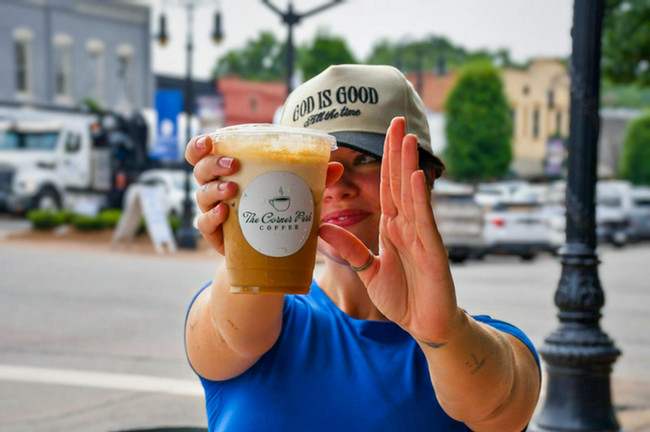 The Corner Perk owner Tristan Burns poses with The Highlander, the coffee shop's signature drink inspired by Gordon State College.